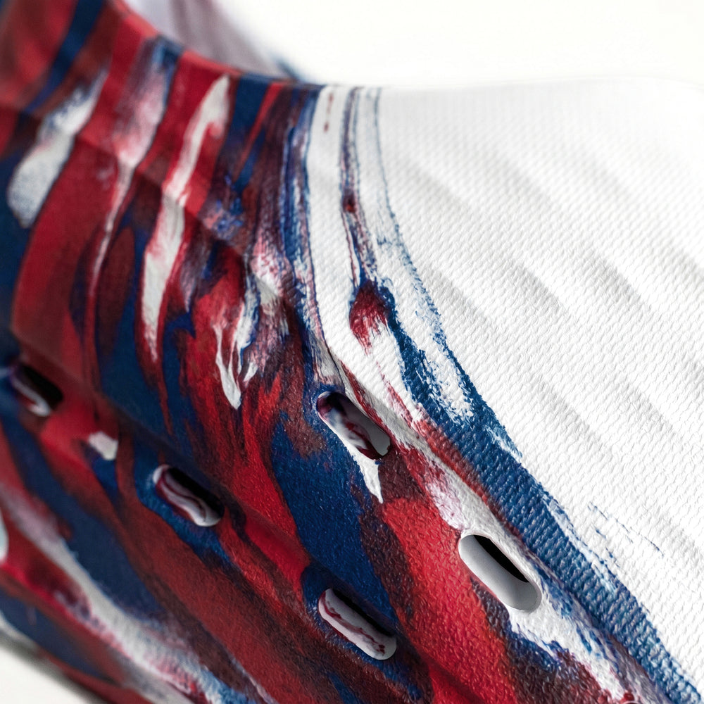 Close-up of a shoe with red, white, and blue abstract design on a white background